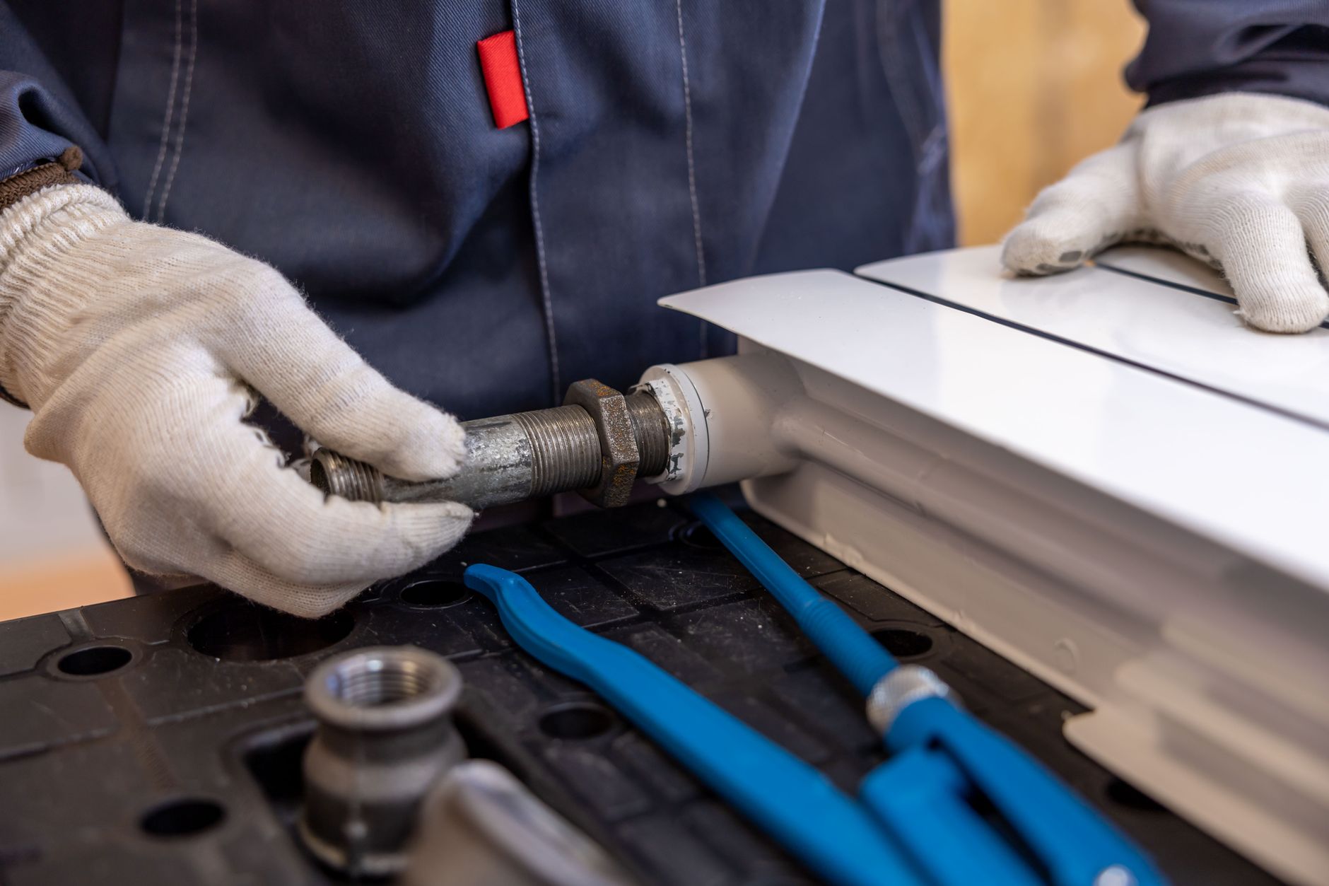 Plumber installing indoor piping with specialized tools